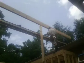 Carpenter setting a ridge beam over a new addition frame — Ice Dam Removal by Roofing Brothers in Mojave