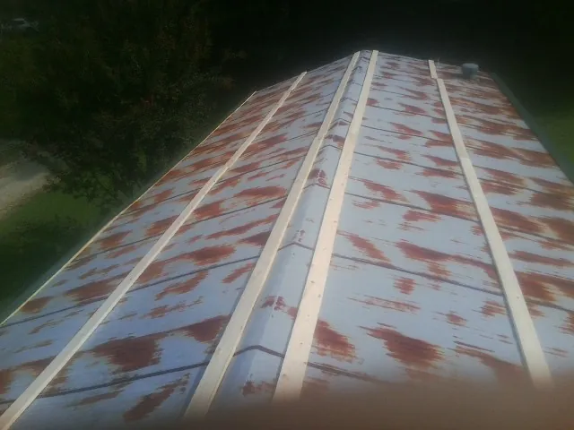 Rusted metal roof panels with new wood purlins before replacement — Storm Damage Roof Repair in Mojave by Roofing Brothers